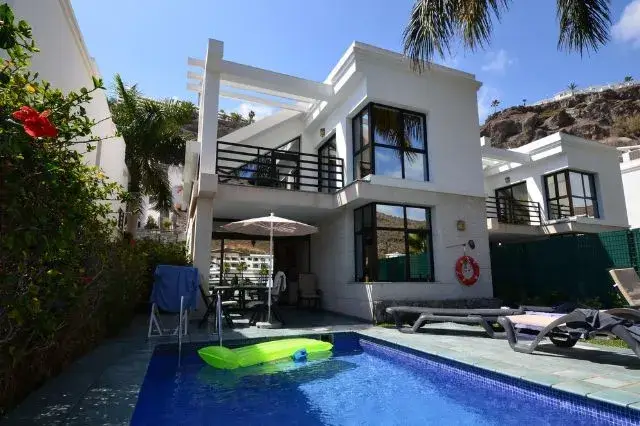 Outdoor swimming pool surrounded by lush gardens at Sunshine Beach Villas, offering a serene alternative to Gran Canaria hotels 5 star.