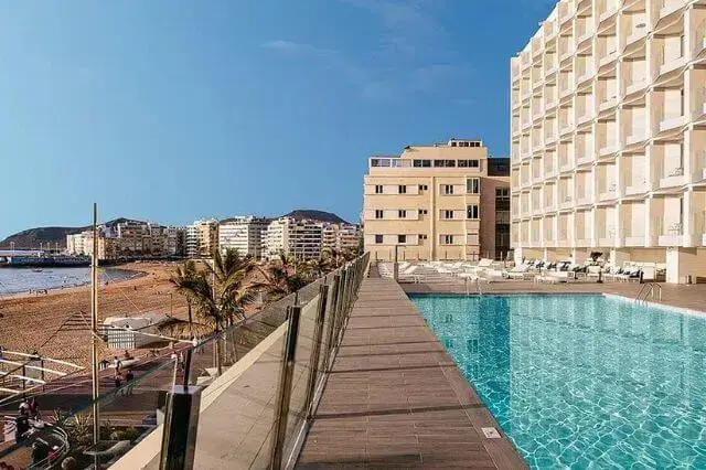 Luxurious 5-star hotel in Gran Canaria with elegant rooms, outdoor pool, and beachfront location.